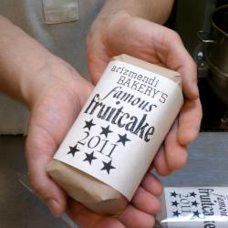 Two hands cradle a small fruitcake.