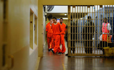 Inmates at Chino State Prison walk the hallway in 2010.