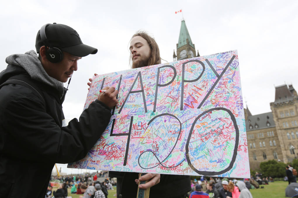 A guy holding a 420 sign