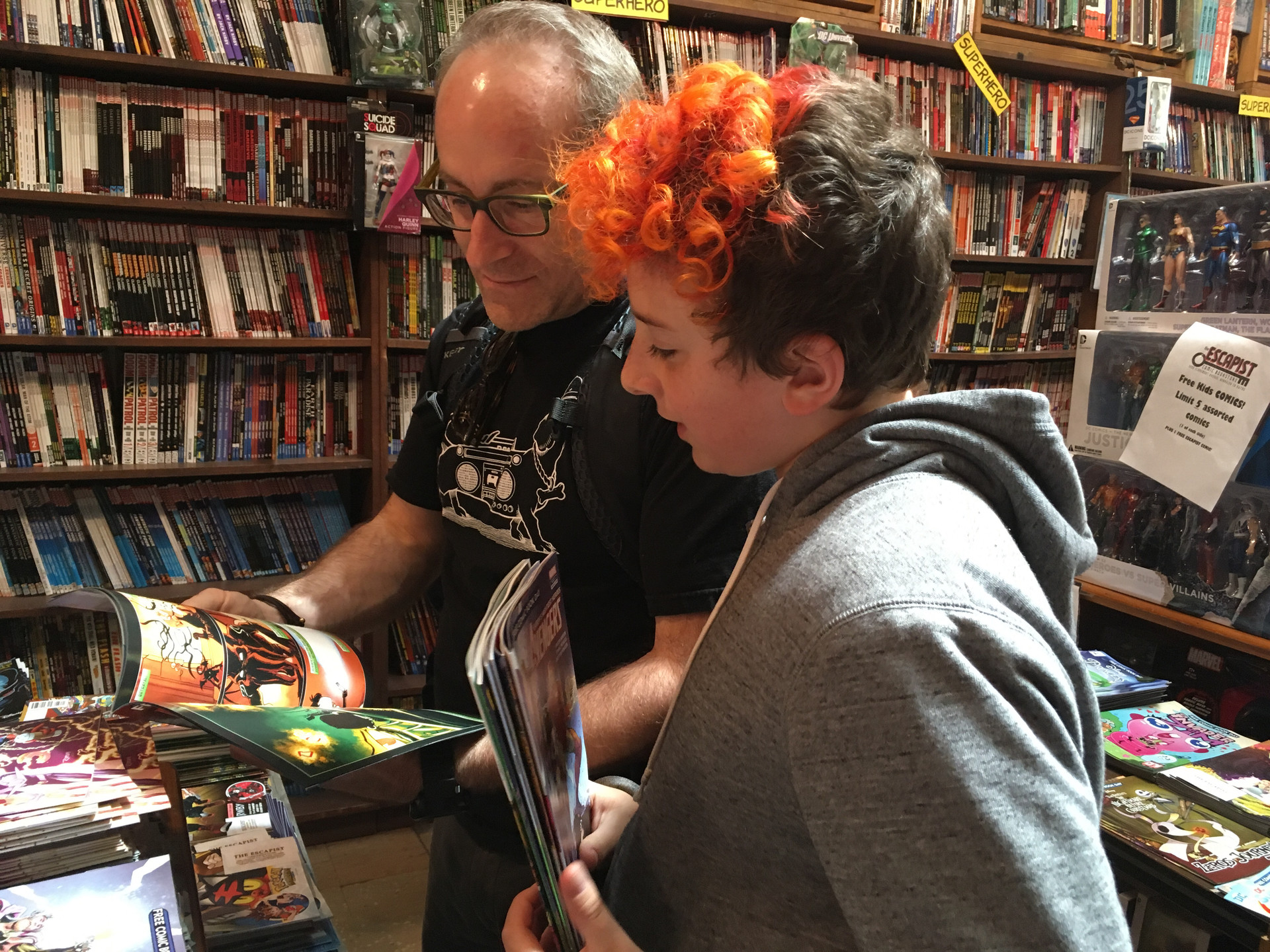 Zachary Schwerin-Dari and his dad Aman Daro look at comics at The Escapist Comic Bookstore. Every year Zachary and his dad go to Free Comic Book Day and then to the library afterwards.