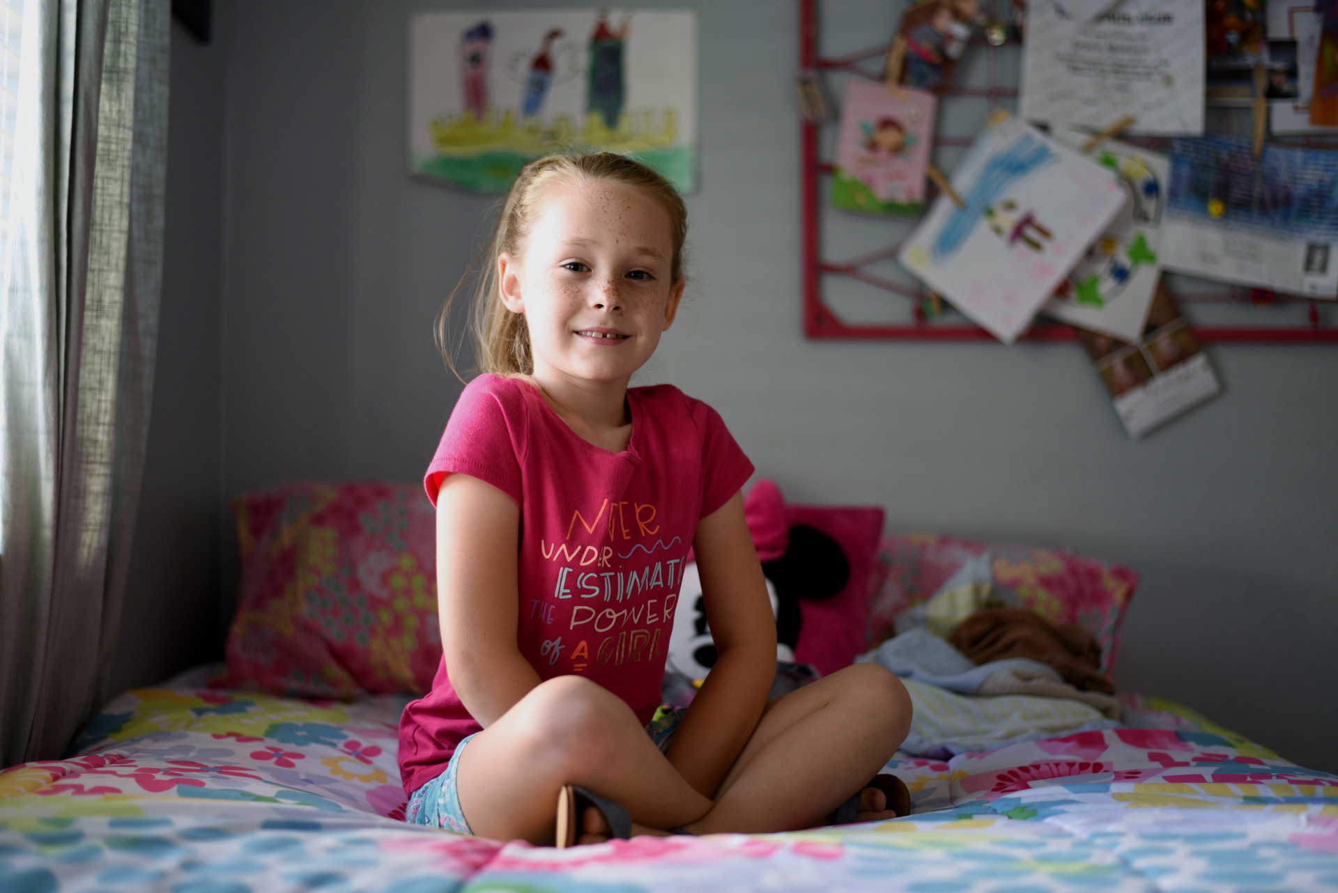 Gracie (7) poses for a picture in her room surrounded by princess and Minni...