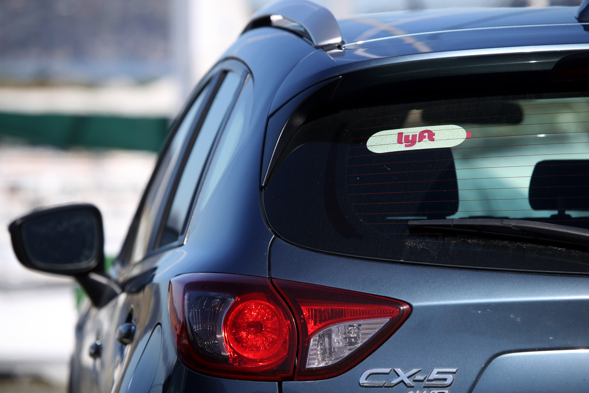 An SUV in San Francisco displaying the Lyft logo in its back window.