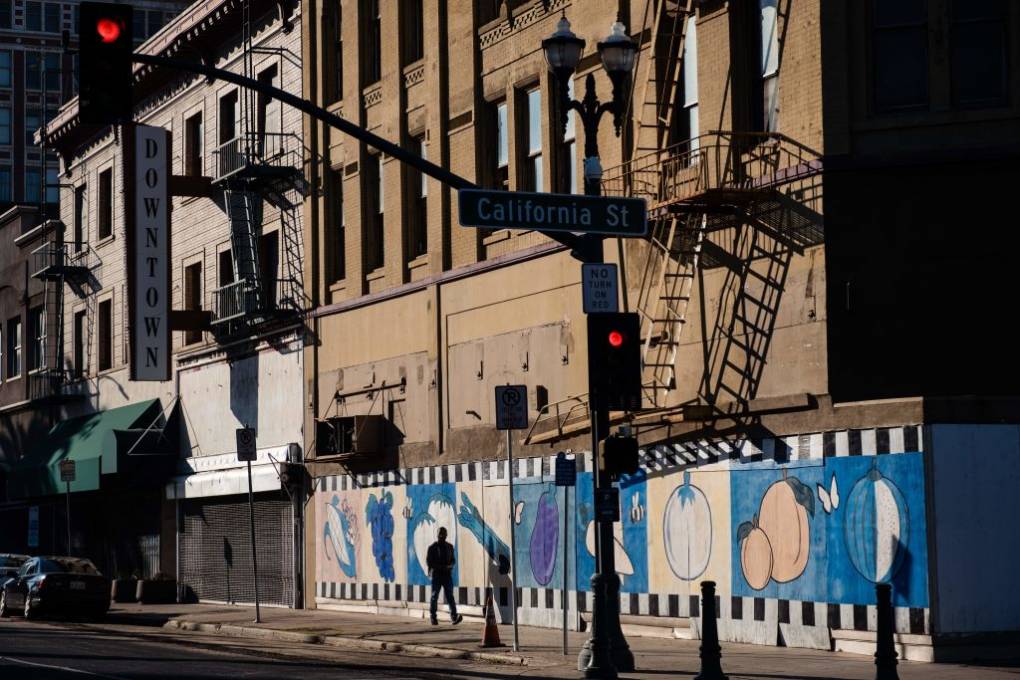 A wide shot of the side of buildings. A person is walking in front of the buildings.