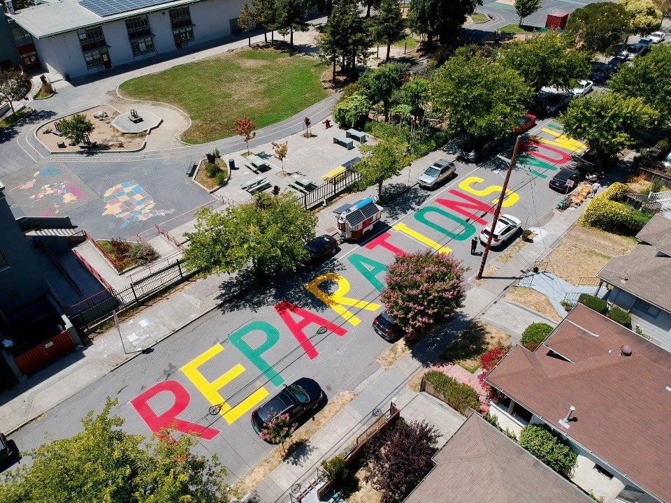 A street mural on Ellis Street in South Berkeley spells out 'Reparations Now!'