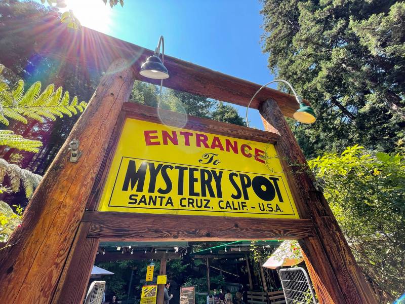 A large yellow-and-black sign reads "Entrance to Mystery Spot, Santa Cruz, Calif. – U.S.A."