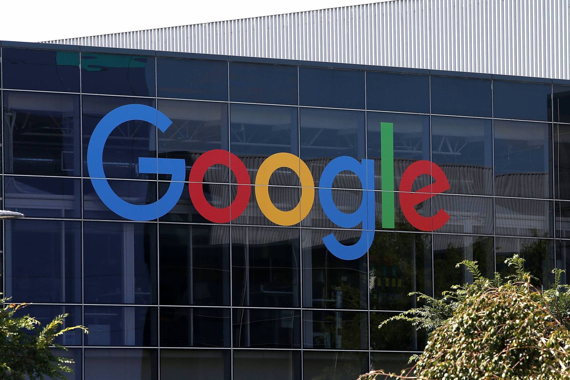 An image of a building with the colorful Google logo on the side. The building looks very modern, the whole wall is a grid of glass windows. The Google logo is the new version.