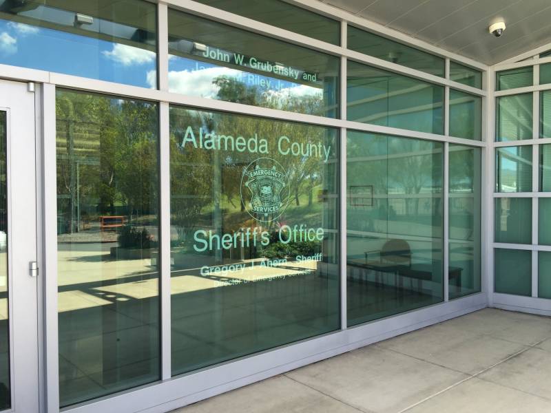 A glass-paned wall that reads 'Alameda County Sheriff's Office.'