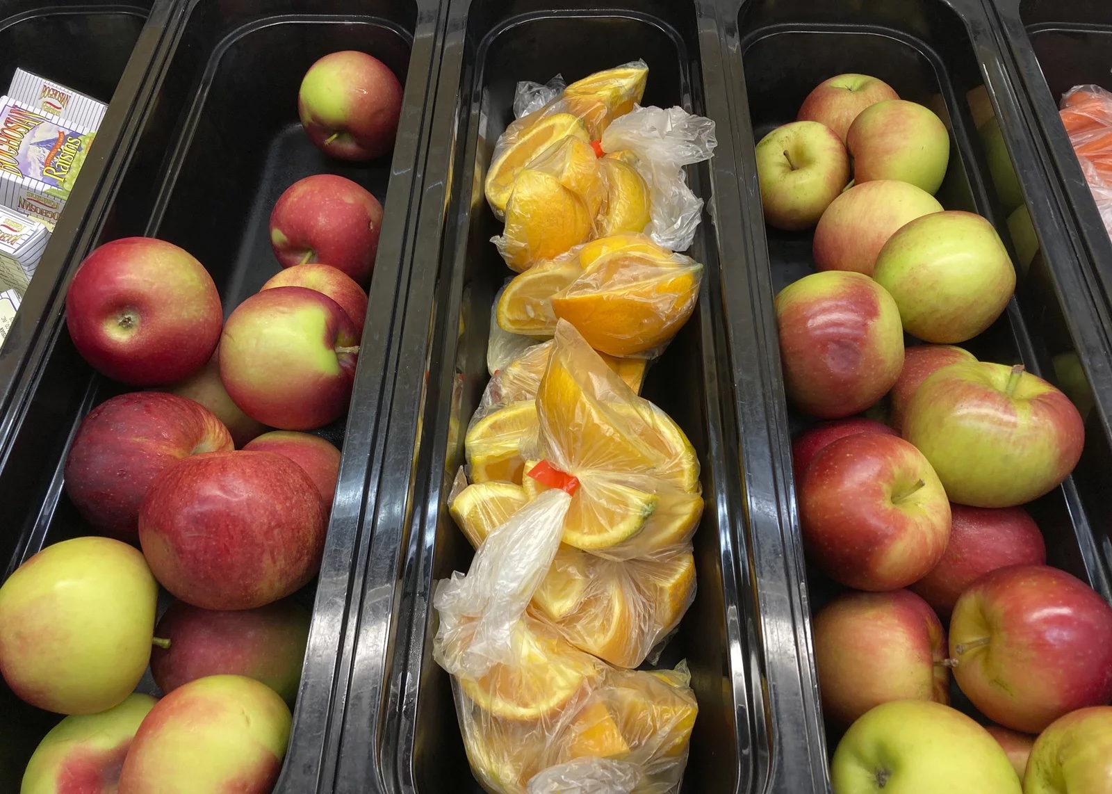 Trays of apples and orange slices.