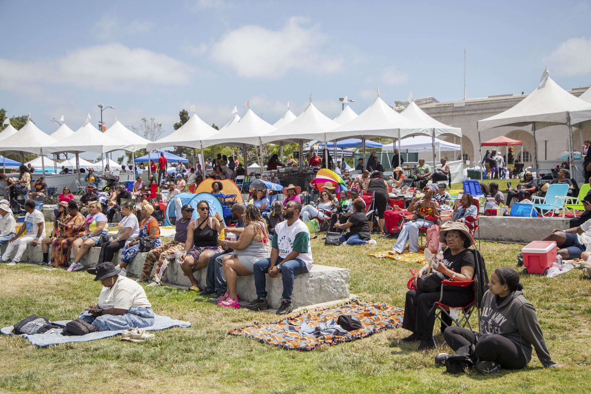 People sit by Lake Merritt during the 14th annual Fam Bam Afrocentric Juneteenth festival in Oakland on June 17, 2023.