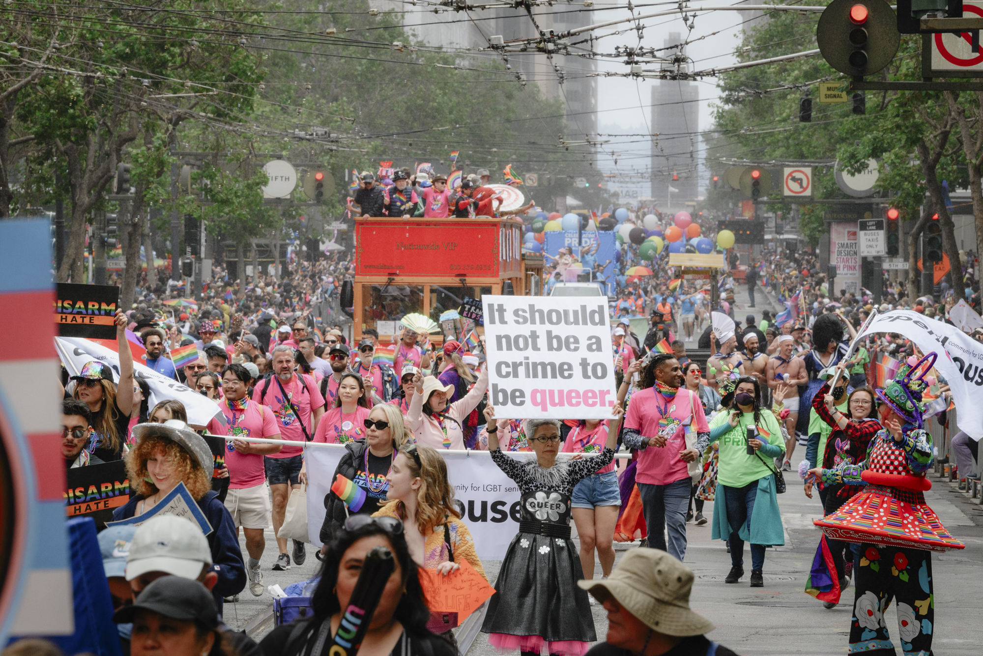 A marcher holds a sign reading “It should not be a crime to be queer” as the Pride parade gets underway in downtown San Francisco on June 25, 2023.