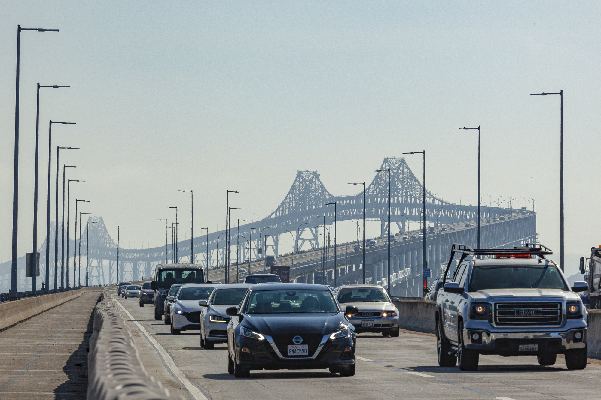 Cars drive over a large bridge.