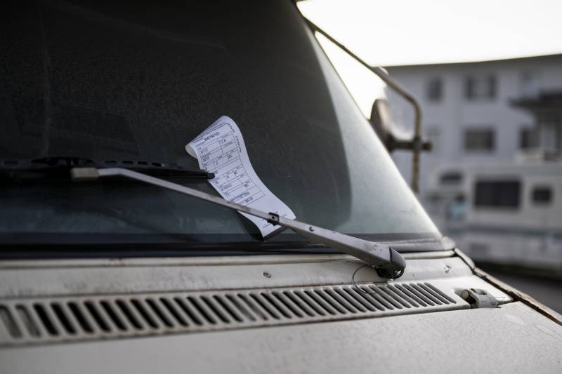 A ticket on a windshield of a vehicle.