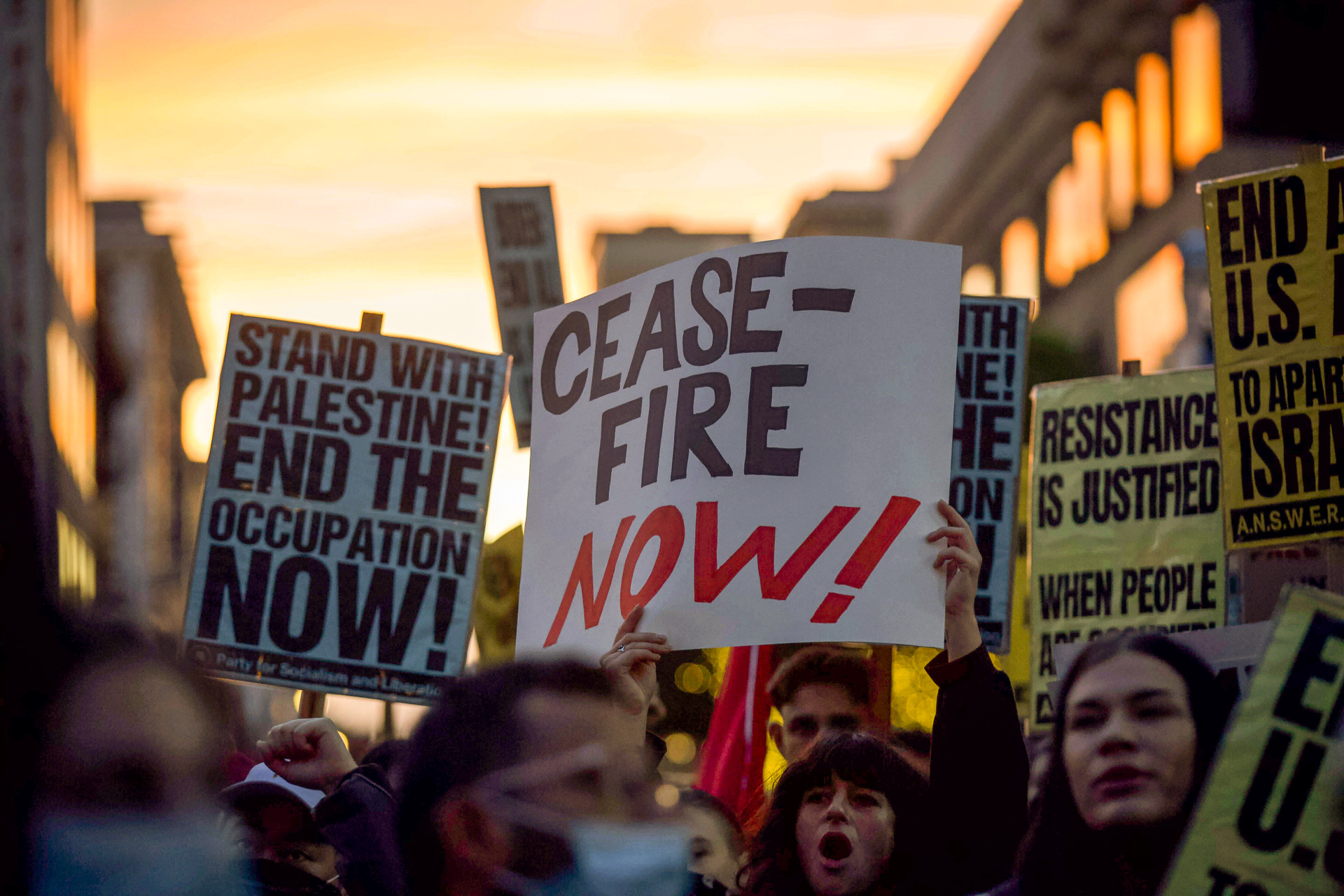 People in a crowd hold protest signs.
