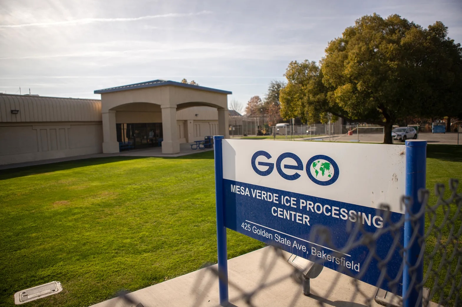 A sign that says GEO outside a building with a lawn.