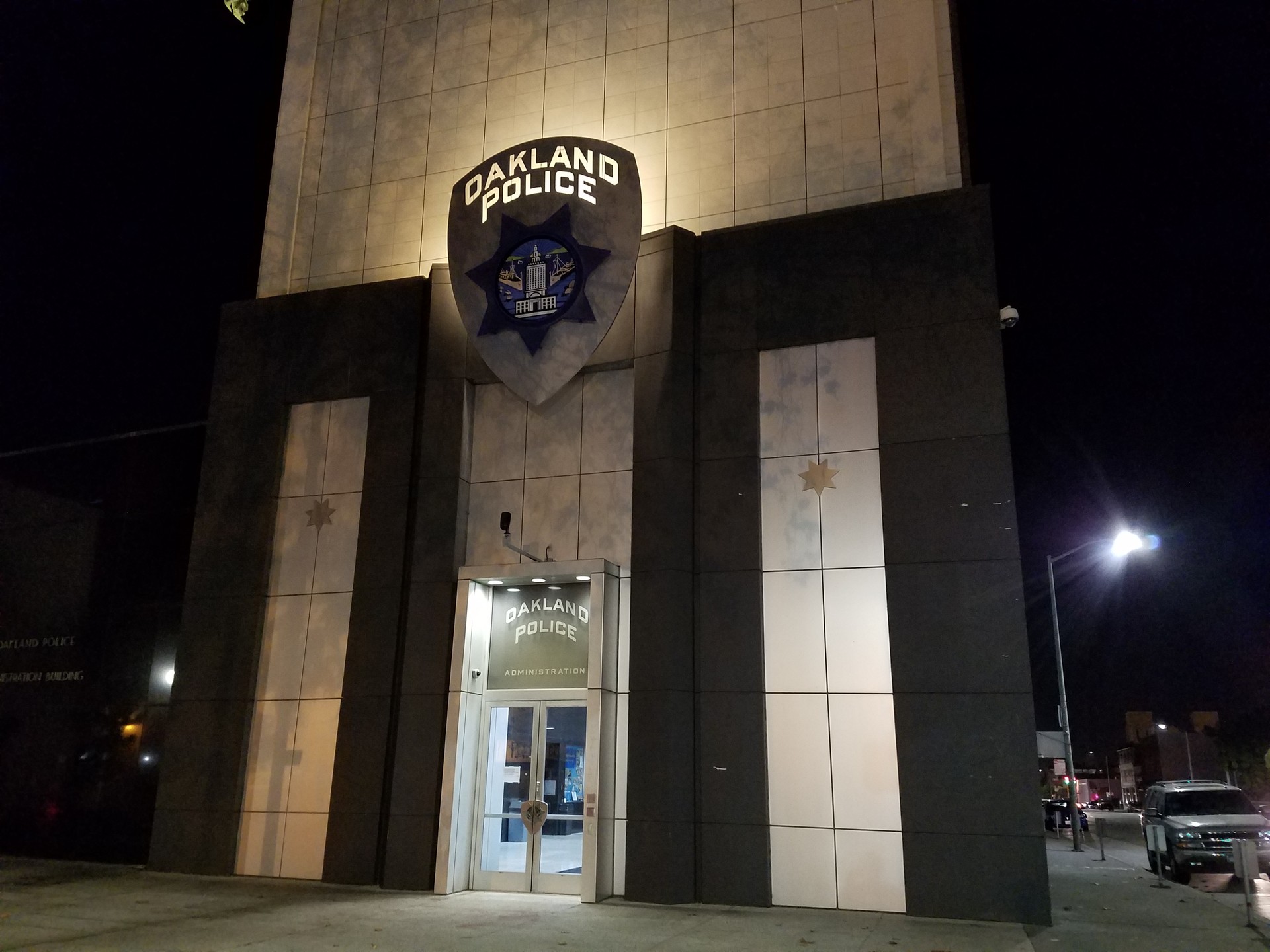 The outside of a building with Oakland Police written on a sign above an entrance.