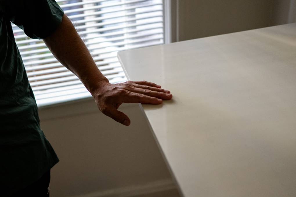 A man's hand is seen resting on a table.