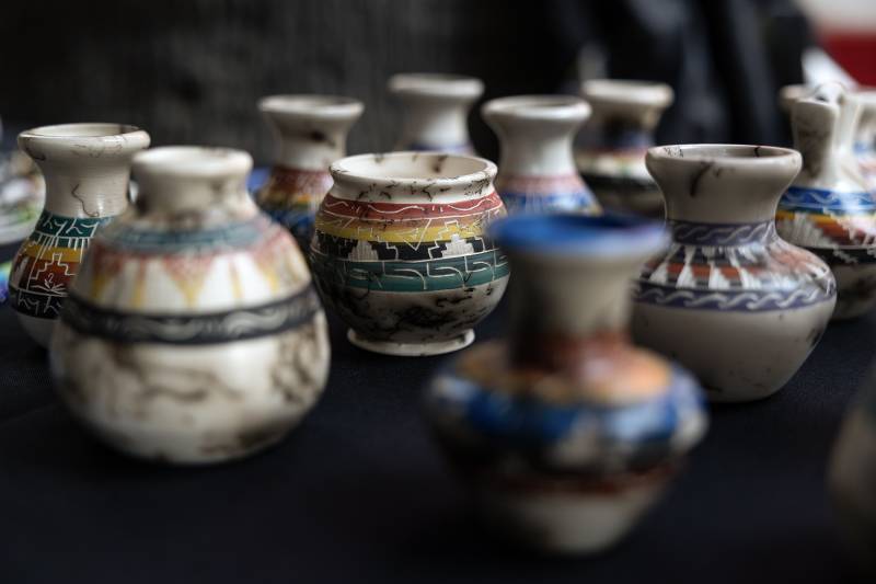 Colorful Native American pottery is pictured. Some of it is weathered.