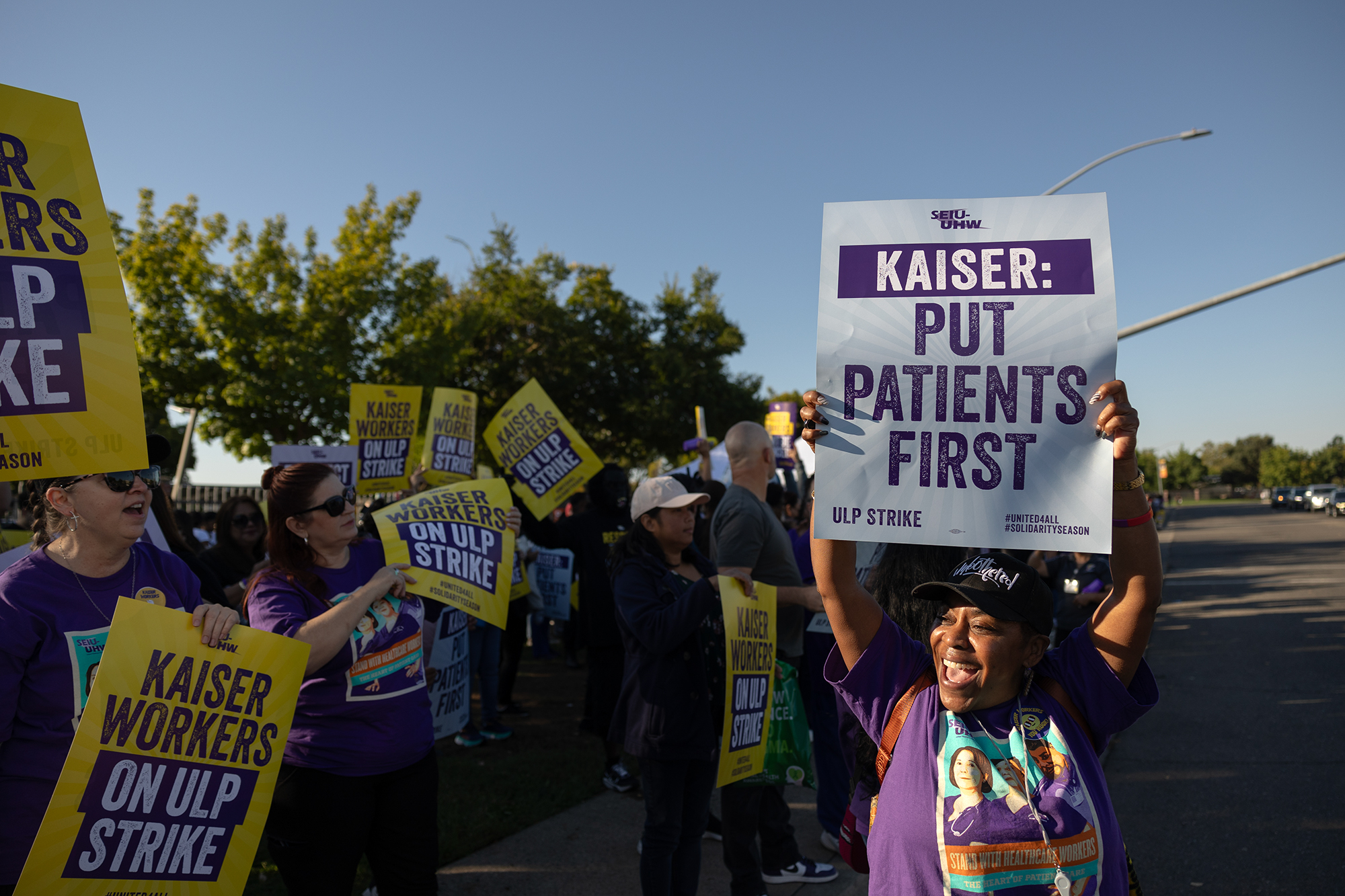 A strike of health care workers hold signs outside of a Kaiser Permanente facility.
