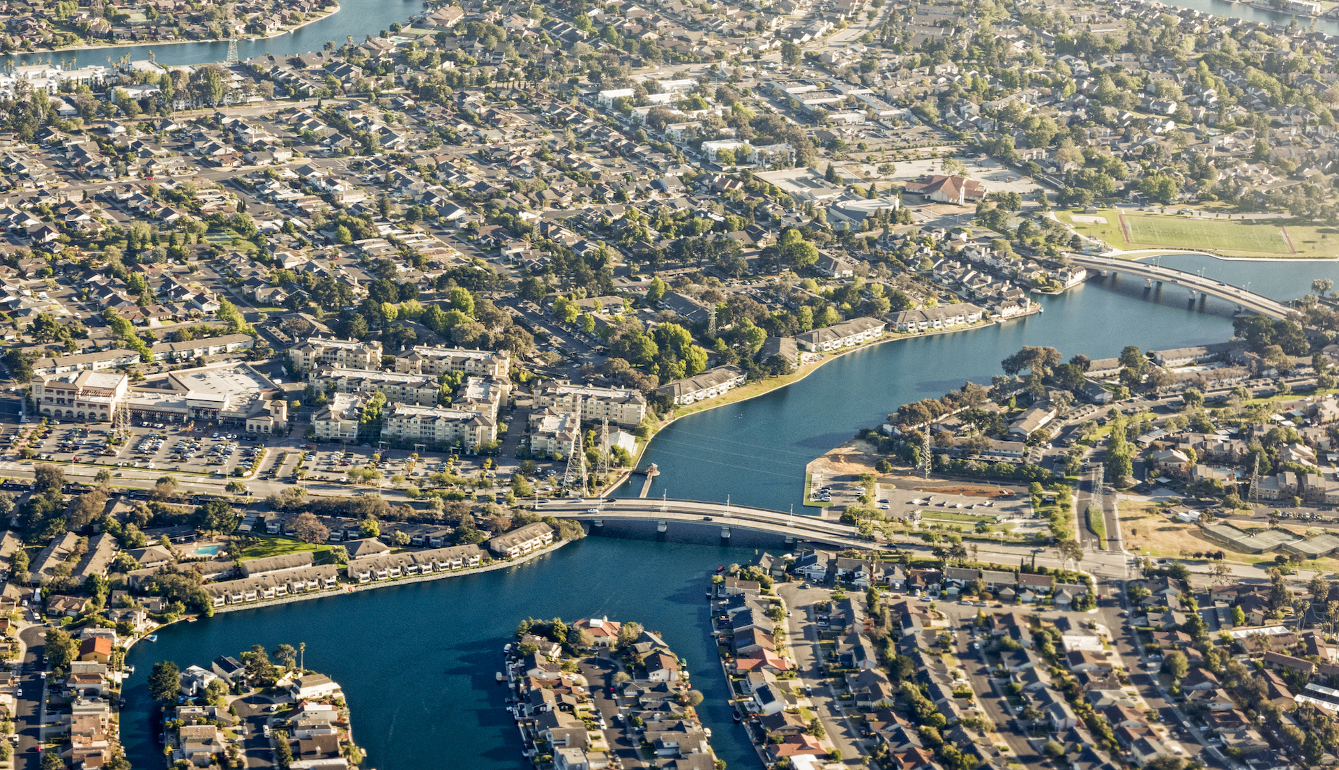 An aerial view of a city, with a bridge over a waterway.