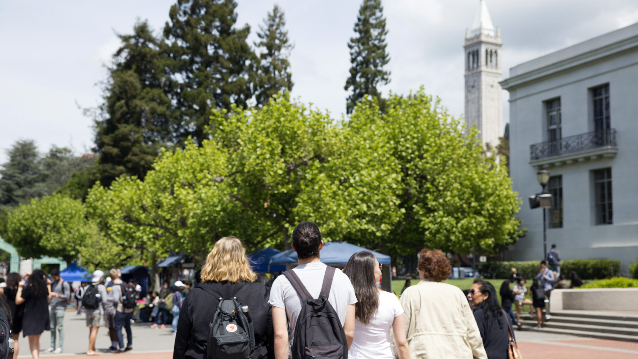 People are seen walking around a campus.