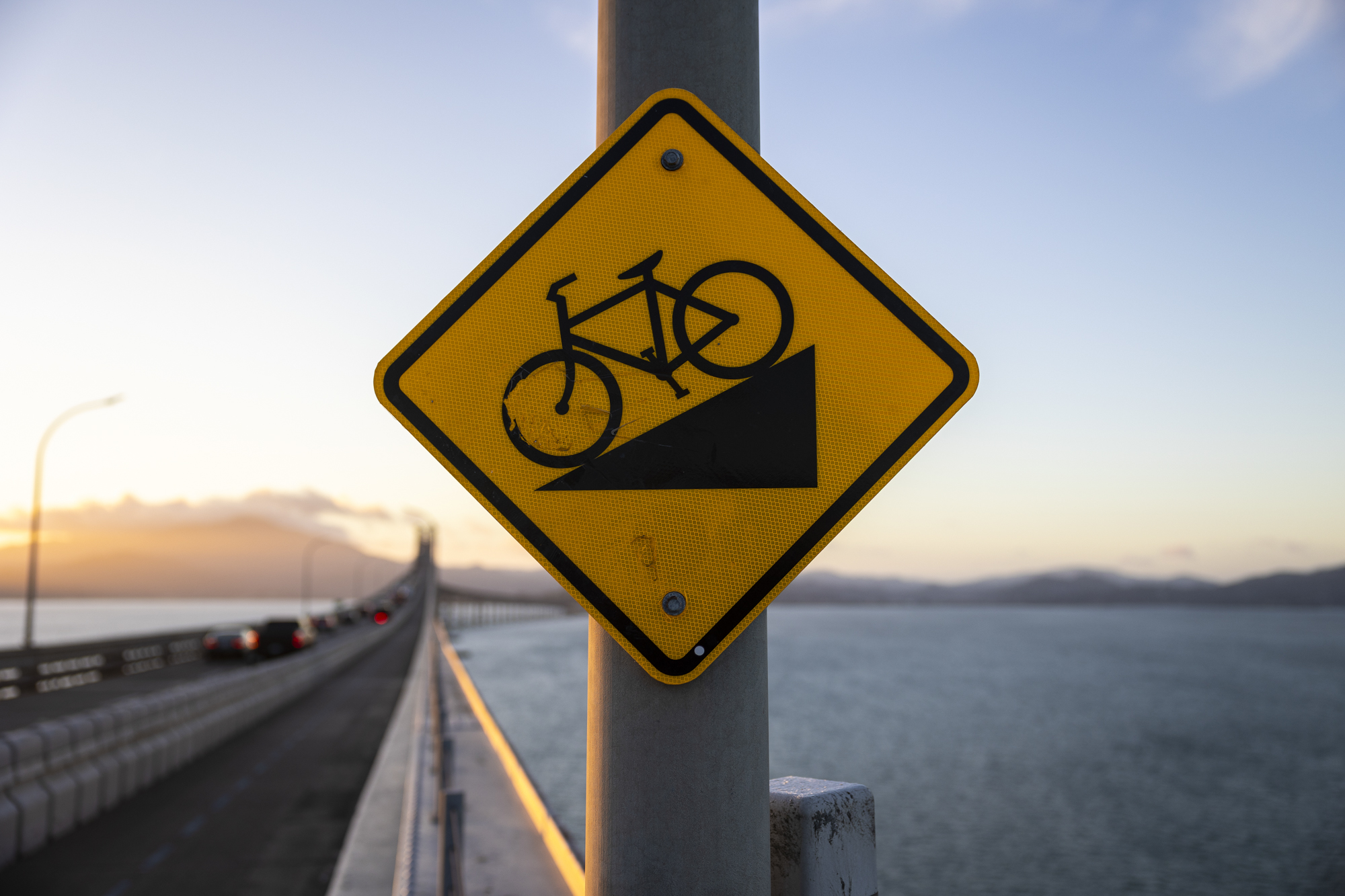 A bright yellow sign with the image of a bicycle on it.