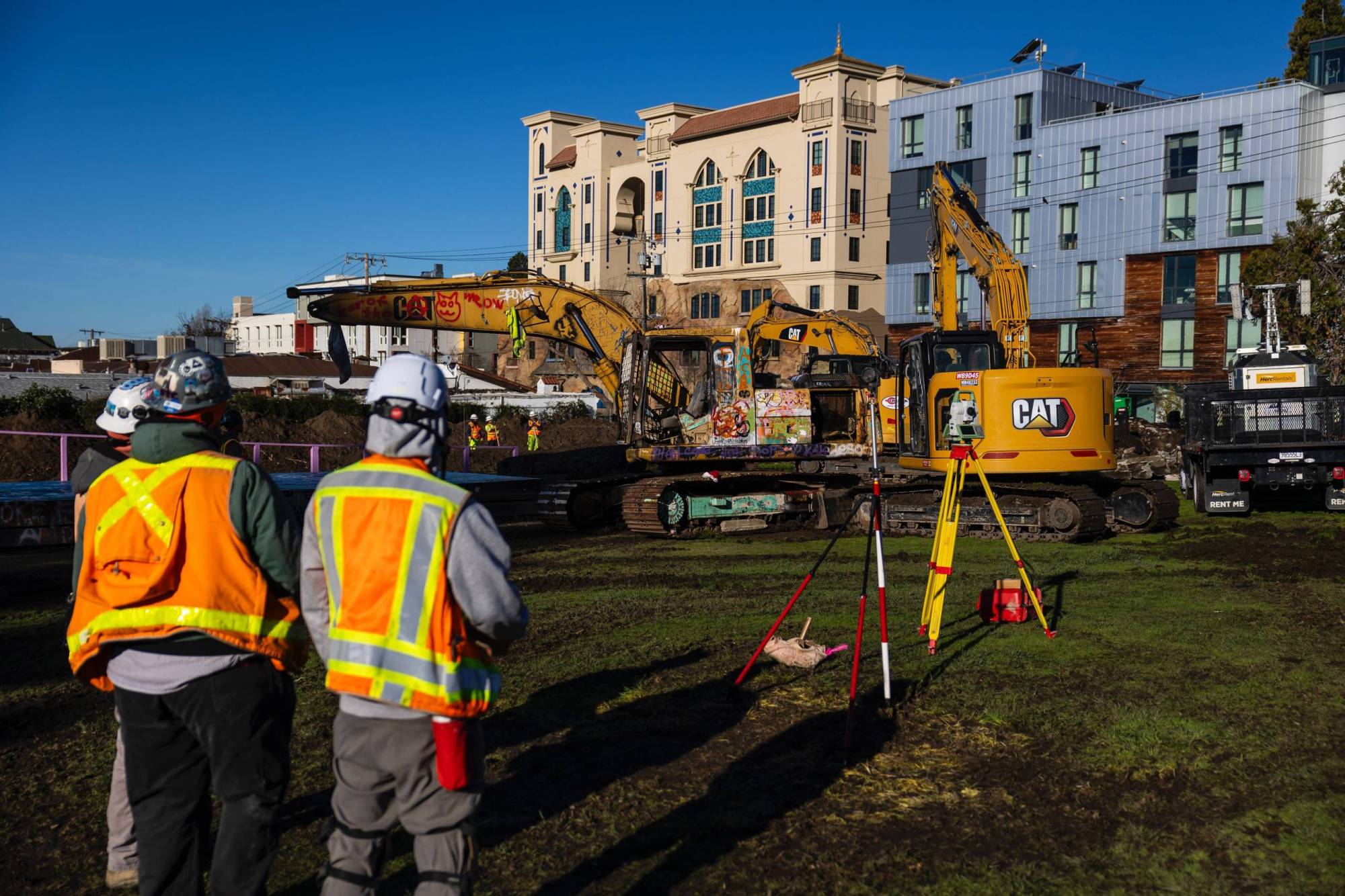 Two construction workers stand on-site at People's Park in Berkeley.