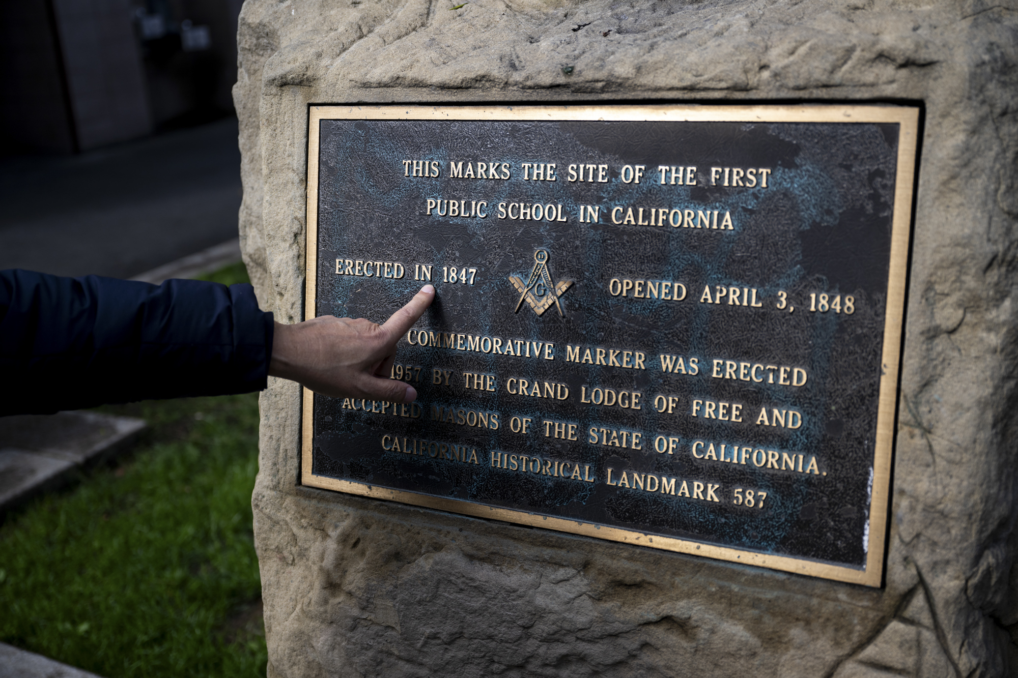 Historian David Lei points to a school house memorial plaque in Portsmouth Square in San Francisco's Chinatown neighborhood on Jan. 22, 2024.