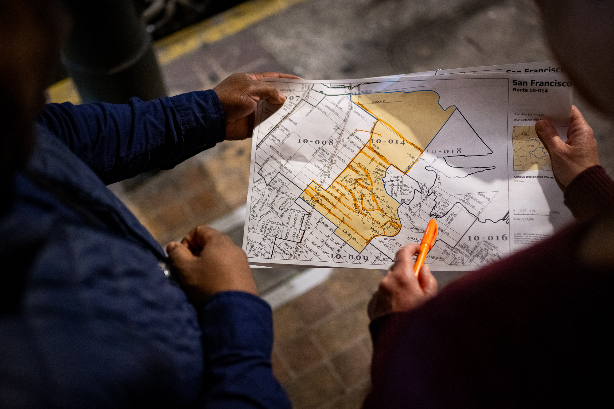 Two hans holding a map of a neighborhood