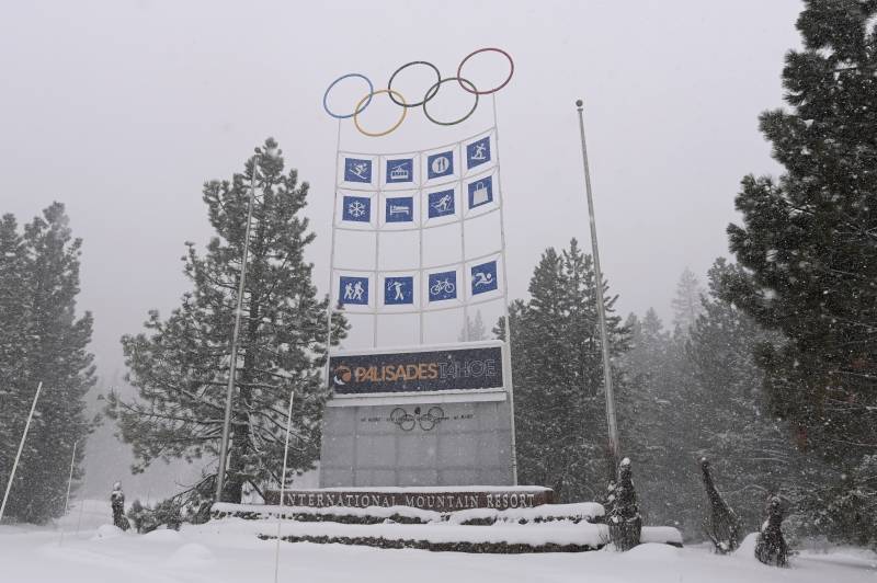 Palisades' sign with the Olympic logo is seen in very snowy, stormy weather.