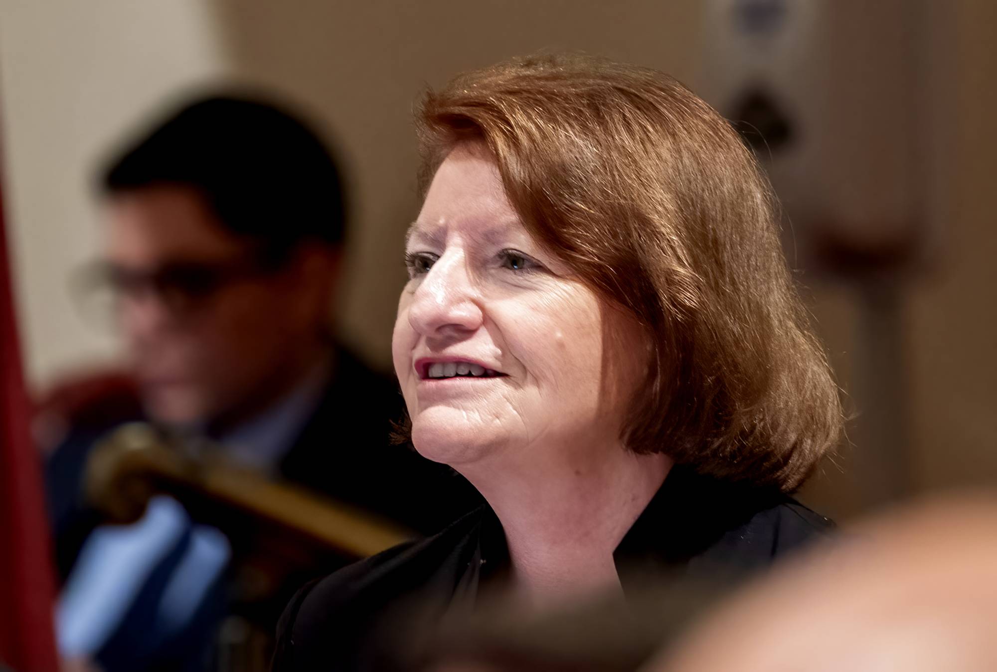 A side profile of a white woman with brown hair.