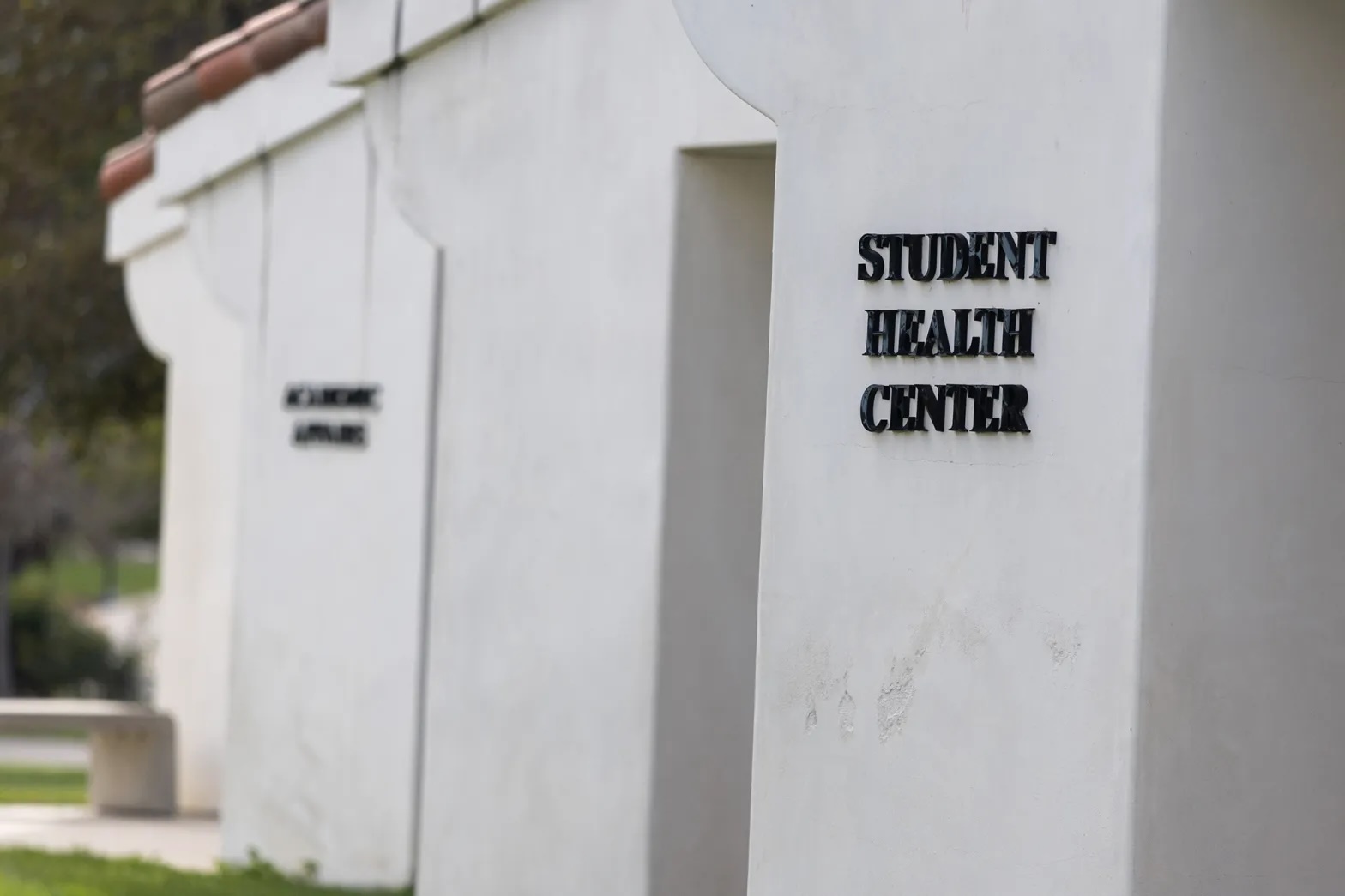 The outside of a white building with "student health center" written on the wall.