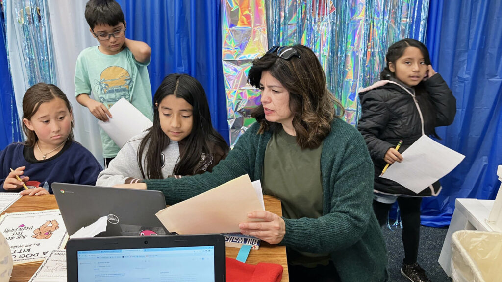 Four students stand near a teacher.