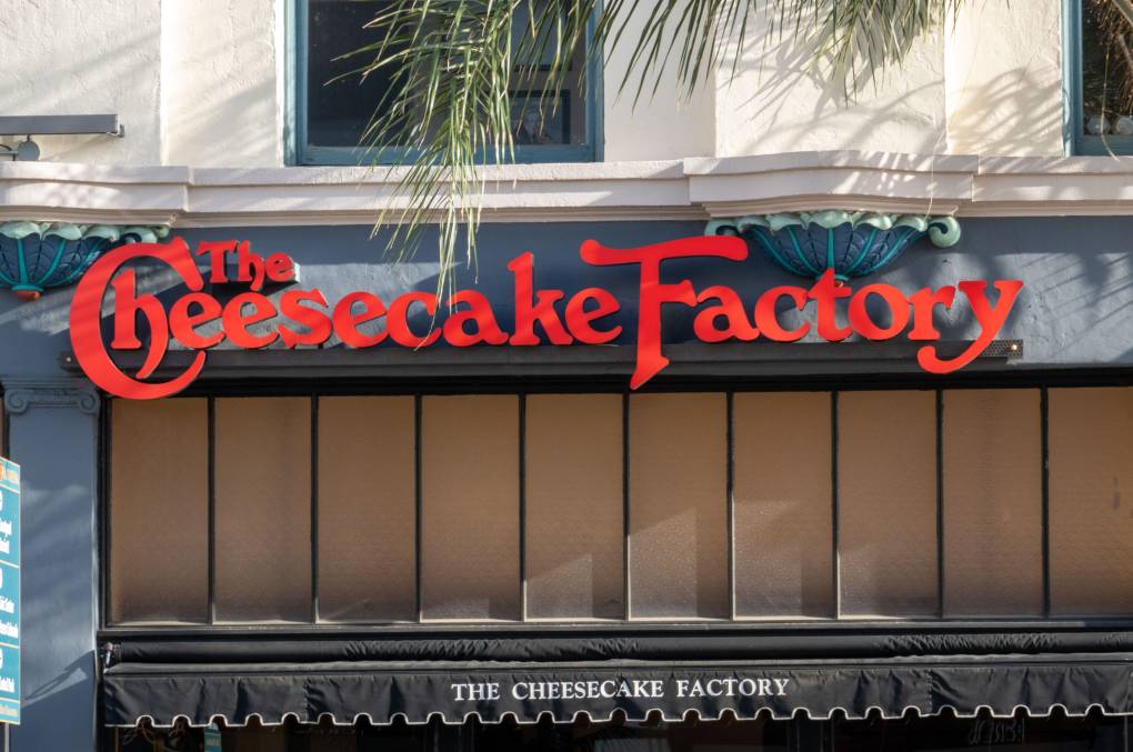An exterior shot of a red Cheesecake Factory sign.