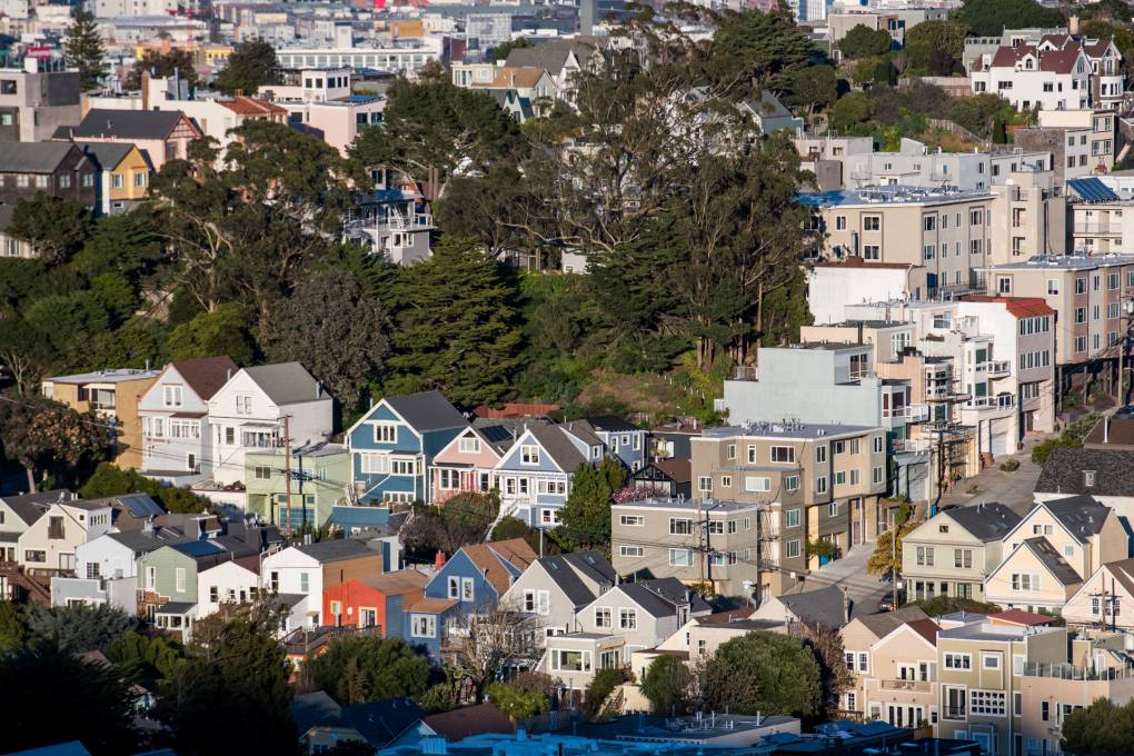Houses in San Francisco, surrounded by trees, are seen from above.