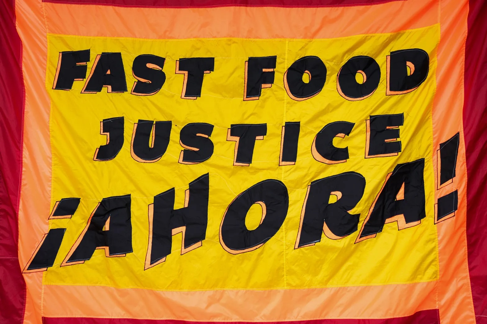 A banner that says "Fast Food Justice Ahora [Now]" 