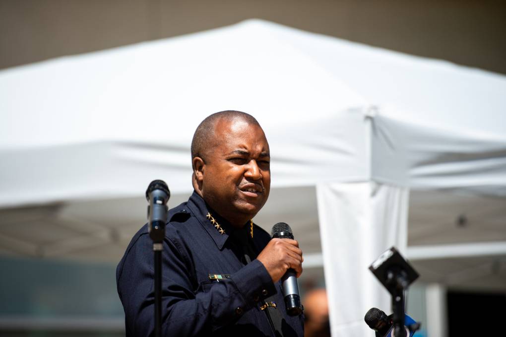Former Oakland Police Chief LeRonne Armstrong speaks with a microphone in hand while in full uniform.
