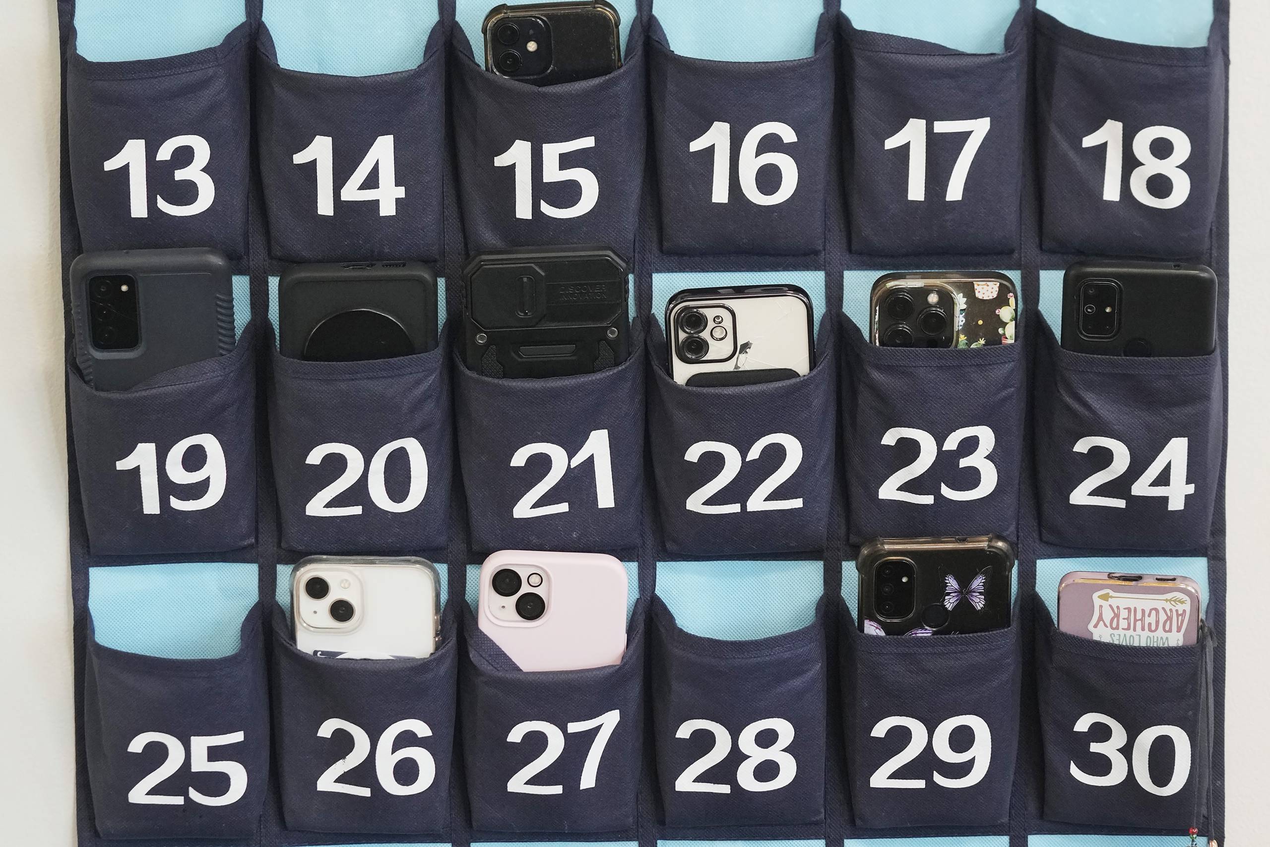 Numbered slots with cellphones in them.