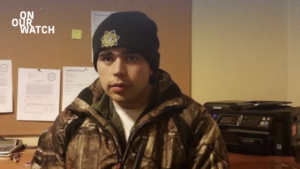 A young man looks at the camera, wearing an official Department of Corrections beanie and a patterned jacket over his uniform. He sits in a nondescript office in front of a bulletin board and a printer.