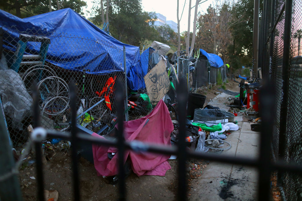 A collection of bikes, tarps and other materials forming an encampment.