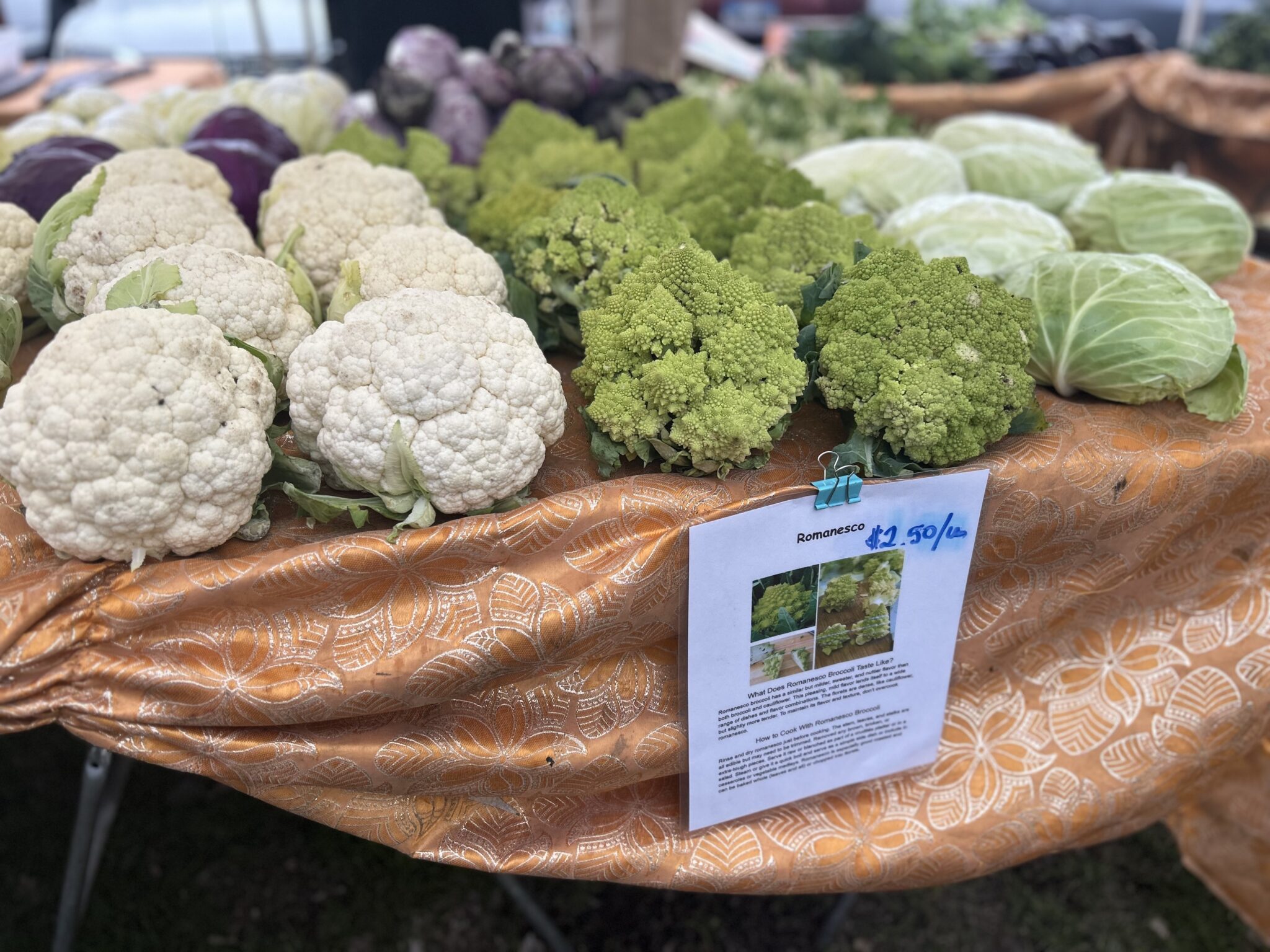 A closeup of farm produce, mostly broccoli and cauliflower.