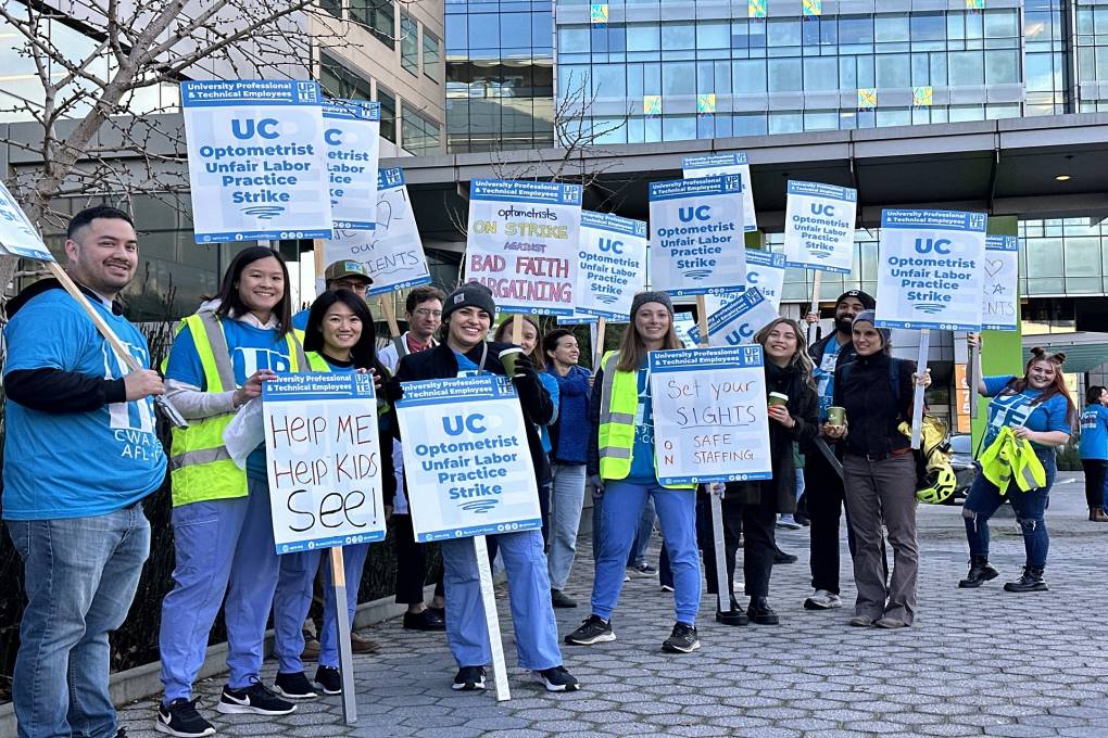 UC optometrists are seen holding signs as they strike for better wages and working conditions.