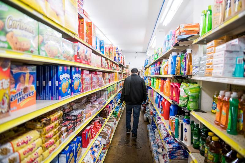 A person walks through the aisles of a grocery store.