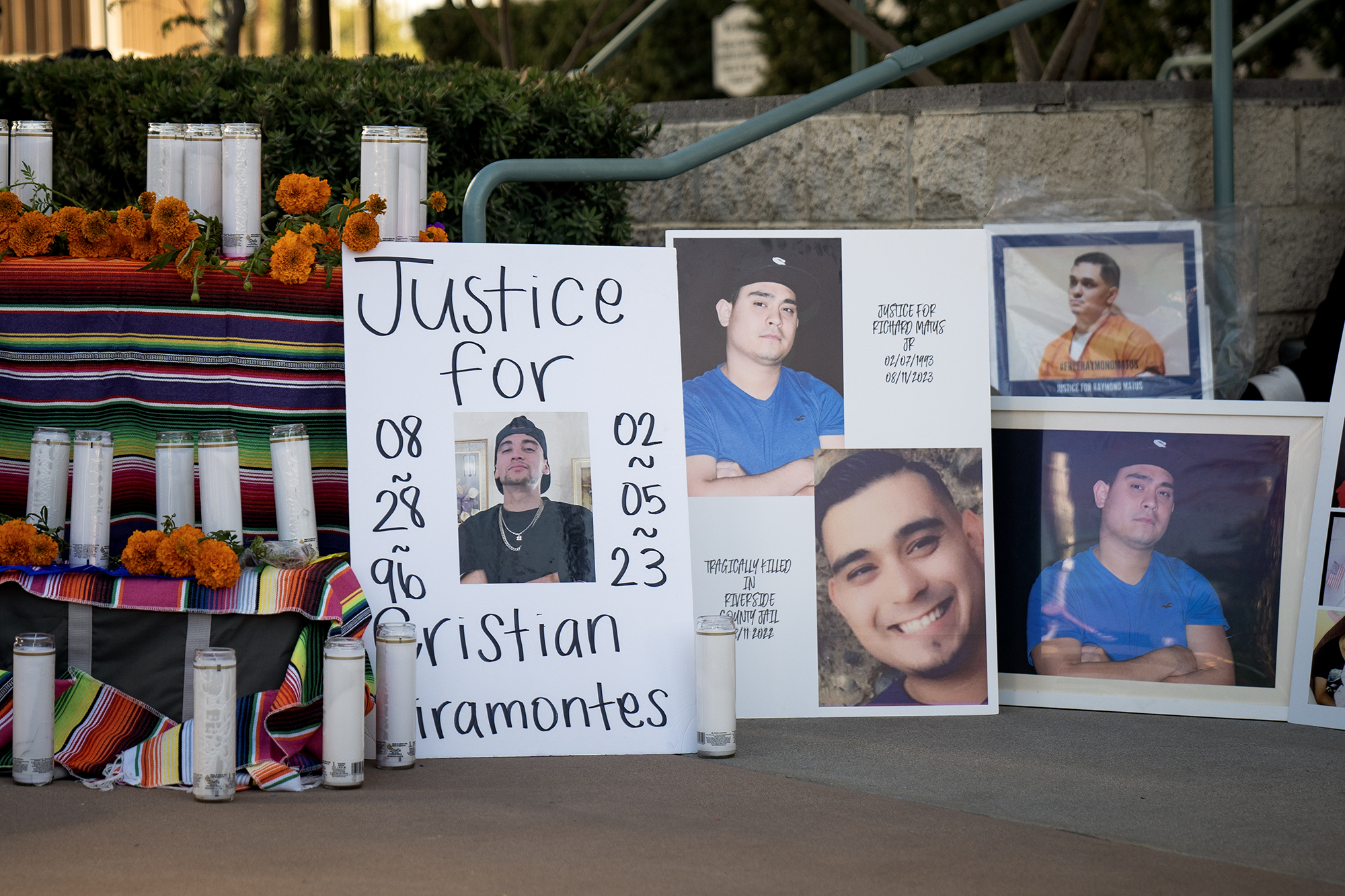 An altar near steps of a building with candles and images of a man.