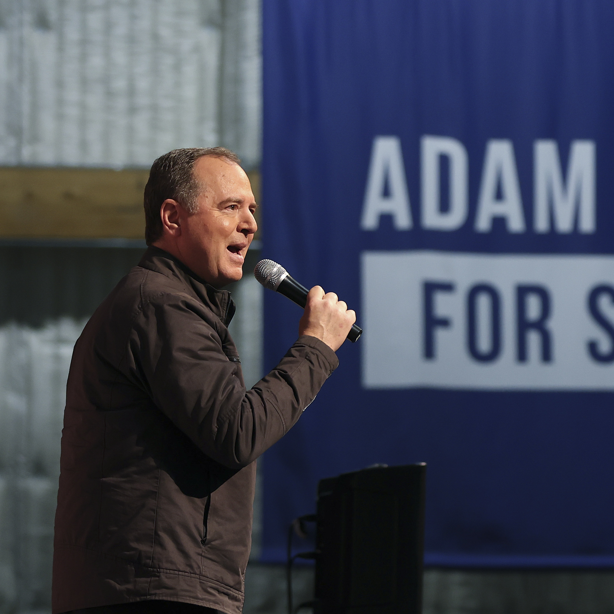 A middle-aged white man speaks into a microphone.