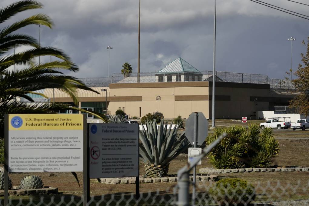 A photo of a large prison behind a fence.