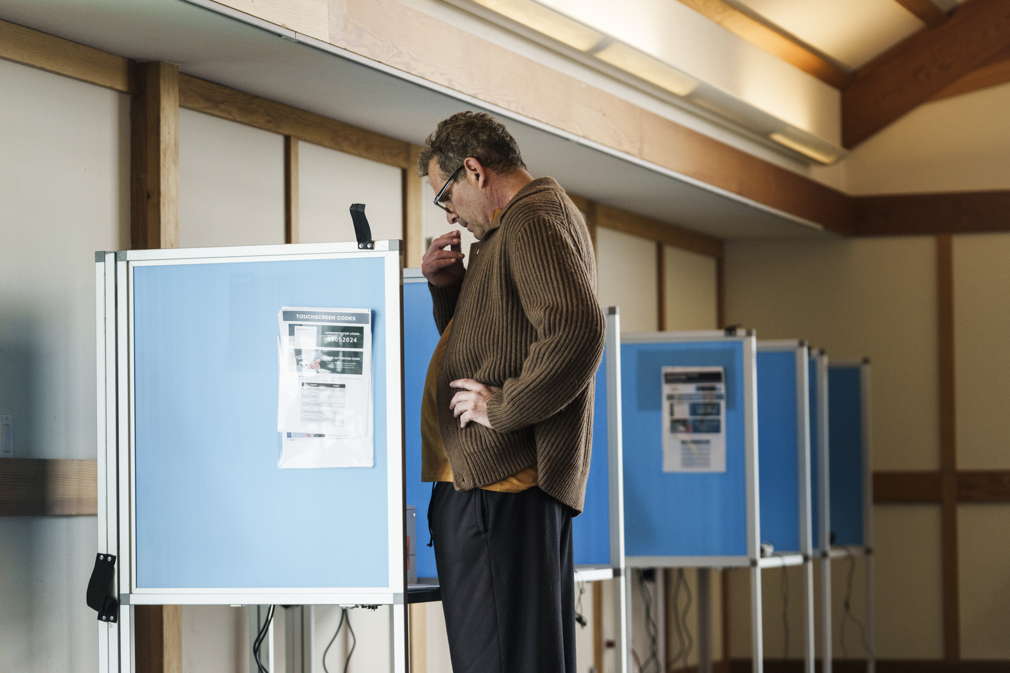 A man votes in what looks like an attic.