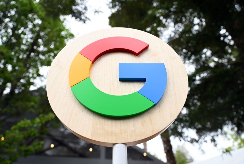 A logo of the letter "G" that is red, yellow, green and blue on a sign post.