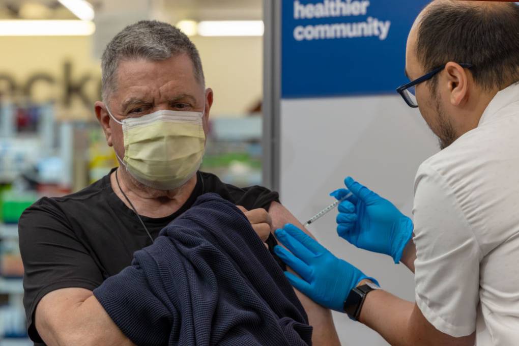 Pharmacist Aaron Sun administers the COMIRNATY® (COVID-19 Vaccine, mRNA) vaccine by Pfizer, to John Vuich at a CVS Pharmacy in Eagle Rock, LA County.  Irfan Khan/Los Angeles Times via Getty Images