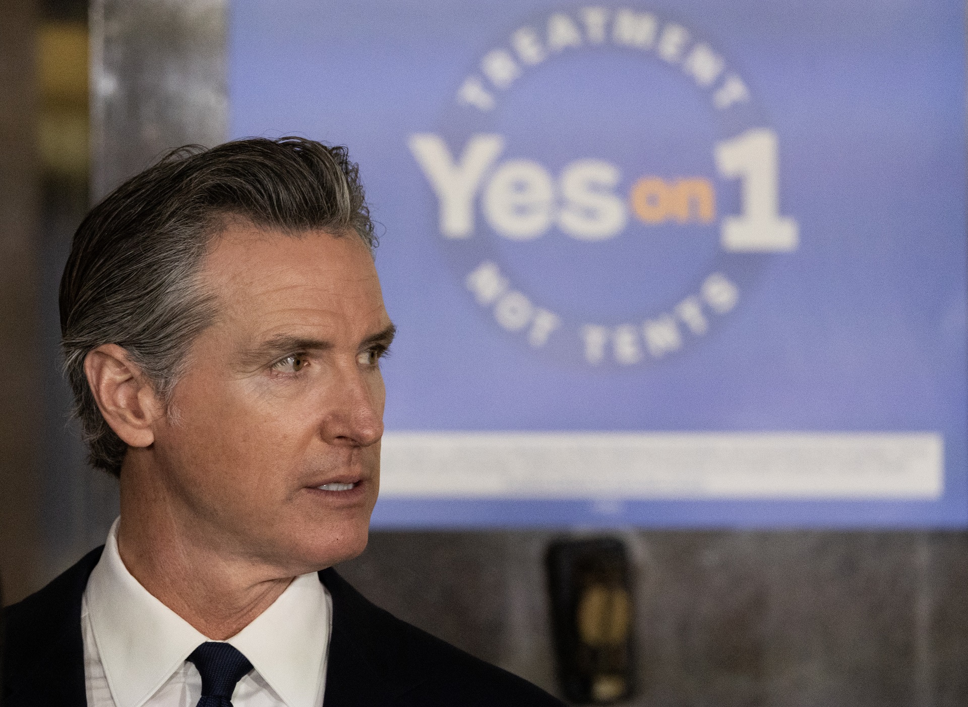 Profile of Governor Gavin Newsom with a "Yes on 1" sign in the background