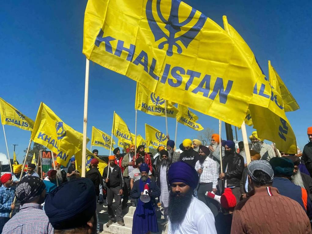 Sikhs holding yellow flags with "Khalistan" written on them.